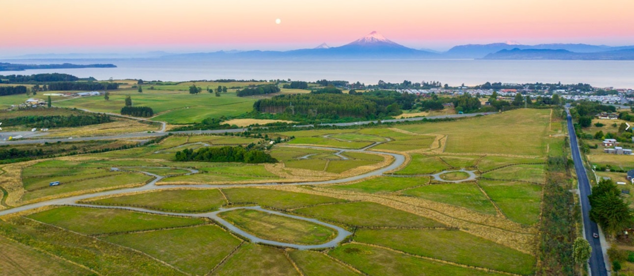 Vista aérea de un loteo en la cuenca del Lago Llanquihue, con lago y volcanes al fondo